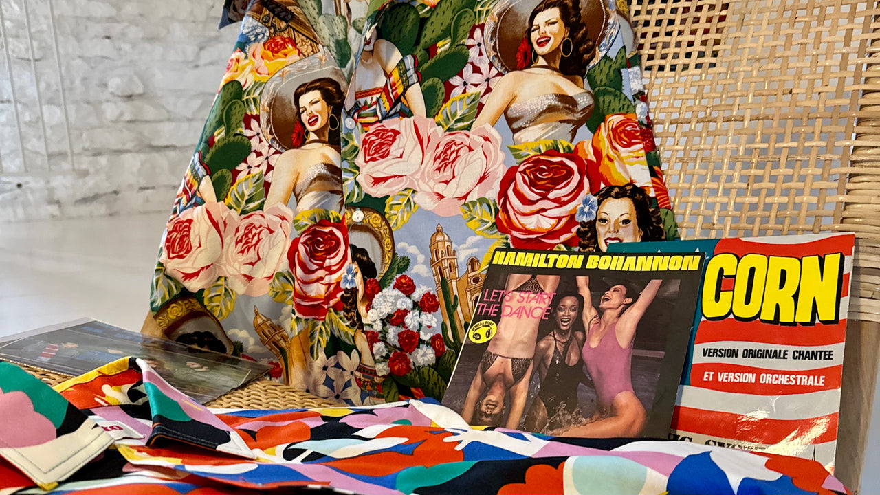 Colourful Tomato shirts and fabrics displayed with vintage records